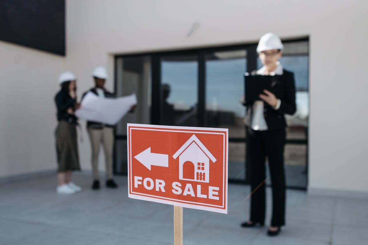 Three real estate professionals inspecting a property for sale with a focus on the business aspect.